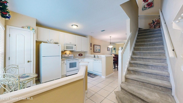 1347 Hampton Park Ln, Melbourne, FL 32940 - kitchen featuring white appliances, light tile patterned flooring, a peninsula, white cabinetry, and hanging light fixtures
