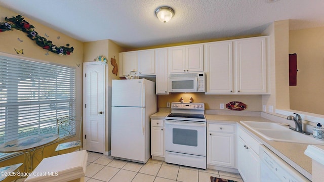 1347 Hampton Park Ln, Melbourne, FL 32940 - kitchen with white appliances, white cabinets, light countertops, light tile patterned flooring, and a textured ceiling