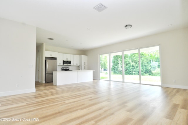 1043 Walden Blvd SE, Palm Bay, FL 32909 - unfurnished living room with light wood-type flooring