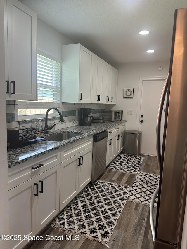 6240 Grissom Pkwy, Cocoa, FL 32927 - kitchen featuring stainless steel appliances, dark wood-style floors, white cabinets, decorative backsplash, and recessed lighting