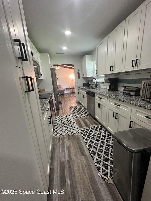 6240 Grissom Pkwy, Cocoa, FL 32927 - kitchen with appliances with stainless steel finishes, dark wood-style floors, white cabinetry, light stone countertops, and recessed lighting