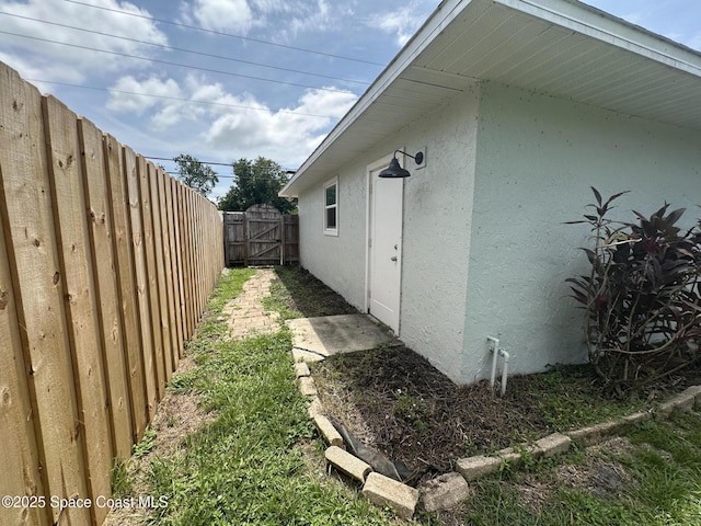 6240 Grissom Pkwy, Cocoa, FL 32927 - view of side of home with stucco siding and a gate