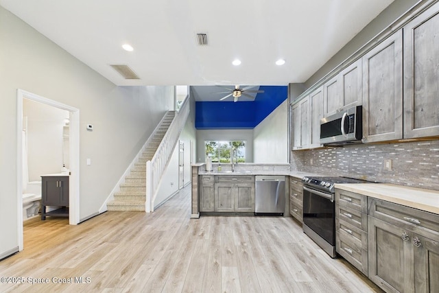 1720 Minutemen Cswy Unit 3, Cocoa Beach, FL 32931 - kitchen featuring appliances with stainless steel finishes, a ceiling fan, decorative backsplash, light wood finished floors, and recessed lighting