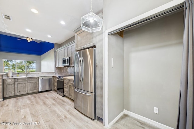 1720 Minutemen Cswy Unit 3, Cocoa Beach, FL 32931 - kitchen with stainless steel appliances, light wood-type flooring, ceiling fan, light countertops, and tasteful backsplash