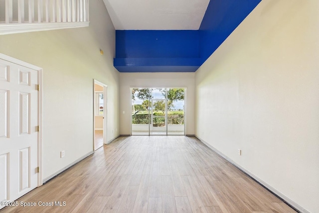 1720 Minutemen Cswy Unit 3, Cocoa Beach, FL 32931 - spare room with a towering ceiling and wood finished floors