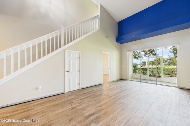 1720 Minutemen Cswy Unit 3, Cocoa Beach, FL 32931 - unfurnished living room with a high ceiling and wood finished floors