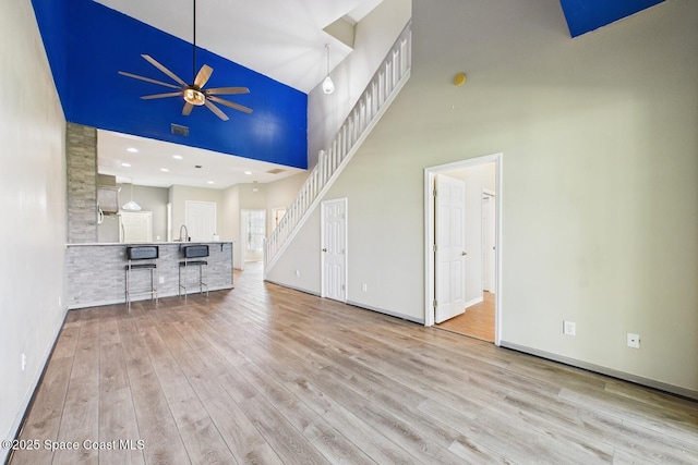 1720 Minutemen Cswy Unit 3, Cocoa Beach, FL 32931 - unfurnished living room with a towering ceiling, ceiling fan, and wood finished floors