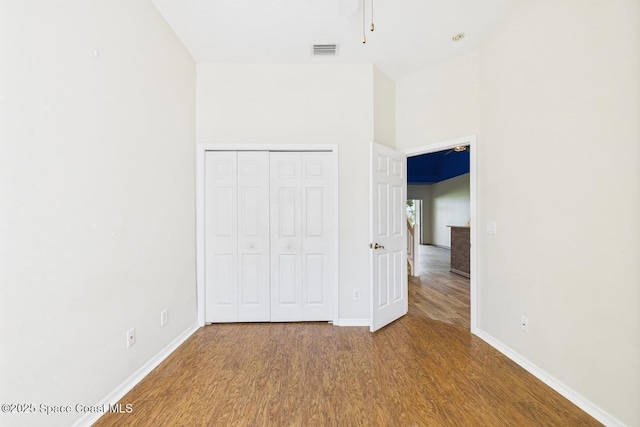 1720 Minutemen Cswy Unit 3, Cocoa Beach, FL 32931 - unfurnished bedroom with wood finished floors, a closet, and a towering ceiling