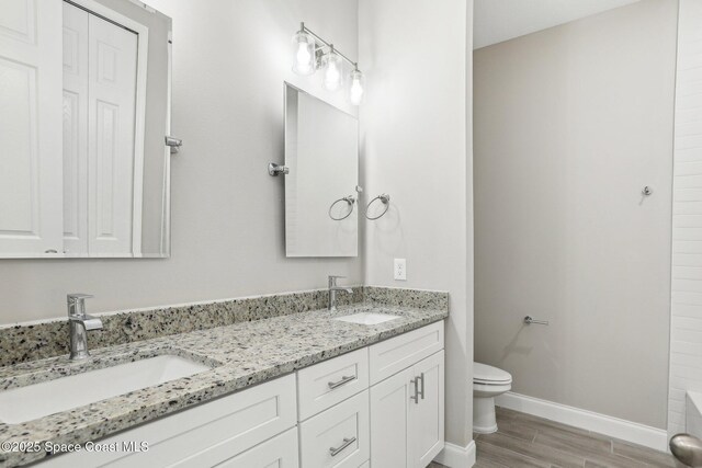 1049 Towhlen St SE, Palm Bay, FL 32909 - full bathroom with double vanity, wood finished floors, and a tub