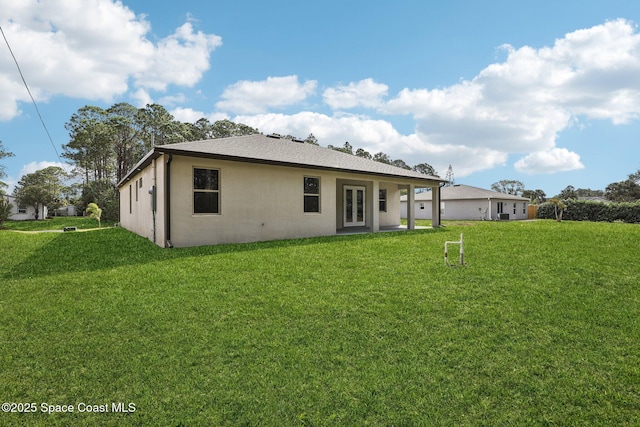 1049 Towhlen St SE, Palm Bay, FL 32909 - rear view of property featuring french doors, a lawn, roof with shingles, and stucco siding