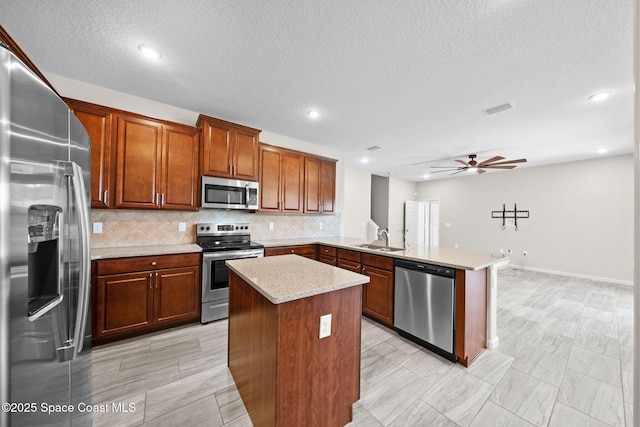 3645 Salt Marsh Cir, West Melbourne, FL 32904 - kitchen with stainless steel appliances, a peninsula, ceiling fan, decorative backsplash, and a kitchen island