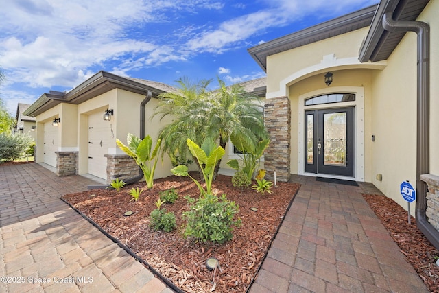 3645 Salt Marsh Cir, West Melbourne, FL 32904 - view of exterior entry with stucco siding, a garage, stone siding, and driveway
