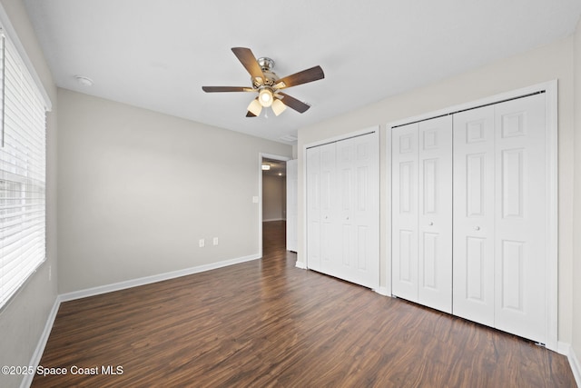 3645 Salt Marsh Cir, West Melbourne, FL 32904 - unfurnished bedroom with multiple closets, dark wood-type flooring, multiple windows, and a ceiling fan