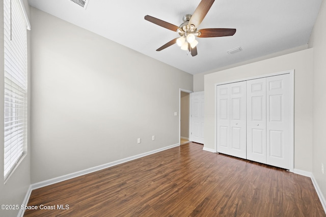 3645 Salt Marsh Cir, West Melbourne, FL 32904 - unfurnished bedroom with dark wood-style floors, multiple windows, a closet, and a ceiling fan