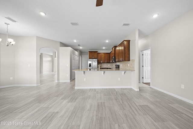3645 Salt Marsh Cir, West Melbourne, FL 32904 - kitchen with stainless steel appliances, arched walkways, a peninsula, a kitchen bar, and open floor plan