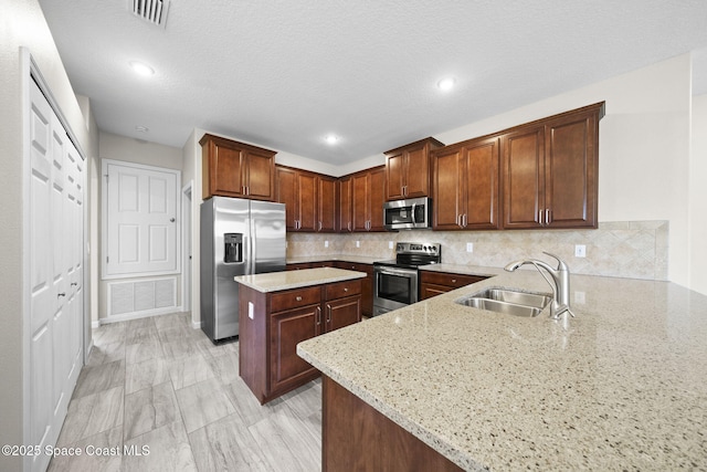 3645 Salt Marsh Cir, West Melbourne, FL 32904 - kitchen featuring appliances with stainless steel finishes, light stone counters, tasteful backsplash, a center island, and a peninsula