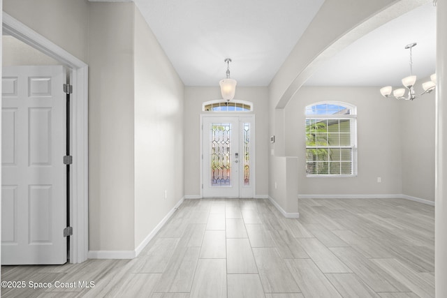 3645 Salt Marsh Cir, West Melbourne, FL 32904 - entryway with arched walkways, a chandelier, and light wood-style flooring