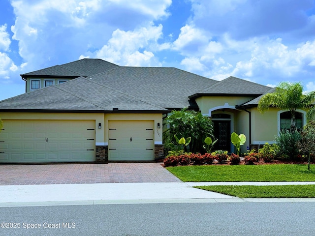 3645 Salt Marsh Cir, West Melbourne, FL 32904 - view of front of home with a garage, decorative driveway, a front yard, stucco siding, and roof with shingles