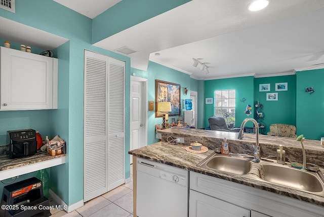 2416 57th Cir, Vero Beach, FL 32966 - kitchen with white dishwasher, light tile patterned floors, white cabinetry, crown molding, and rail lighting
