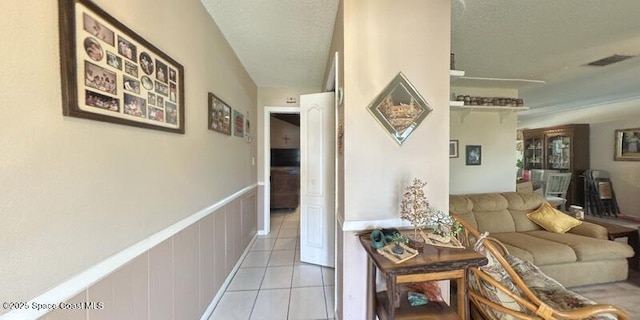 699 Bimini Rd, Satellite Beach, FL 32937 - living area featuring light tile patterned floors, wainscoting, and a textured ceiling