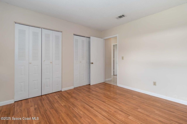 1572 Talavera St SE, Palm Bay, FL 32909 - unfurnished bedroom with multiple closets and light wood finished floors