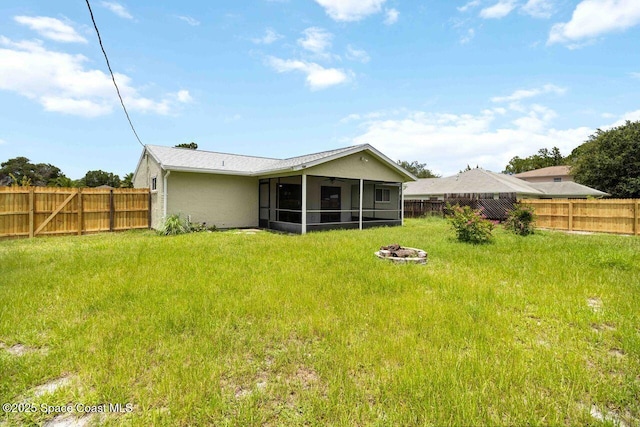 1572 Talavera St SE, Palm Bay, FL 32909 - back of property featuring a fire pit, a sunroom, a fenced backyard, a ceiling fan, and stucco siding