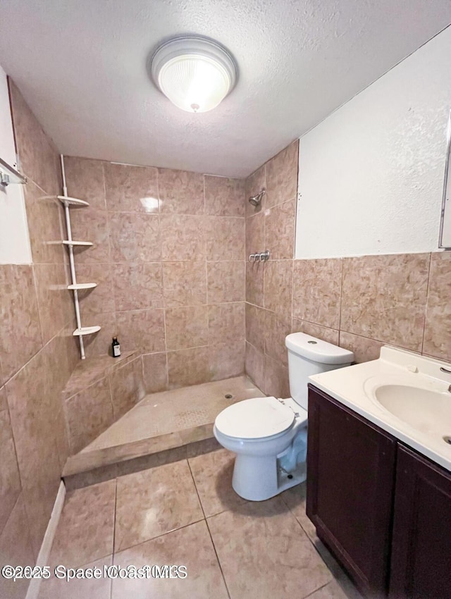 332 Palm Ave, Cocoa, FL 32922 - full bath featuring a tile shower, vanity, tile walls, tile patterned floors, and a textured ceiling