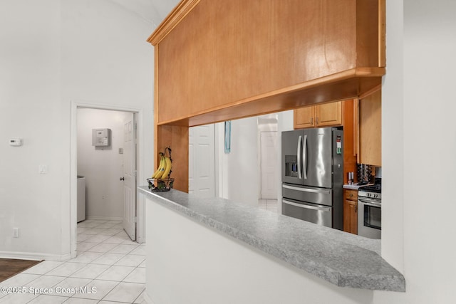 878 Croton Rd, Rockledge, FL 32955 - kitchen featuring appliances with stainless steel finishes, light tile patterned flooring, a peninsula, a towering ceiling, and light countertops