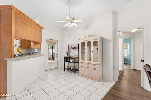 878 Croton Rd, Rockledge, FL 32955 - kitchen featuring light countertops, ceiling fan, light wood-style floors, and high vaulted ceiling