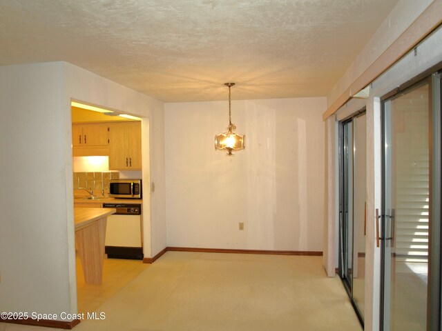9020 York Ln Unit C, West Melbourne, FL 32904 - kitchen featuring stainless steel microwave, white dishwasher, light countertops, a textured ceiling, and decorative light fixtures