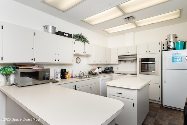 9020 York Ln Unit C, West Melbourne, FL 32904 - kitchen with stainless steel appliances, under cabinet range hood, light countertops, a peninsula, and a kitchen island