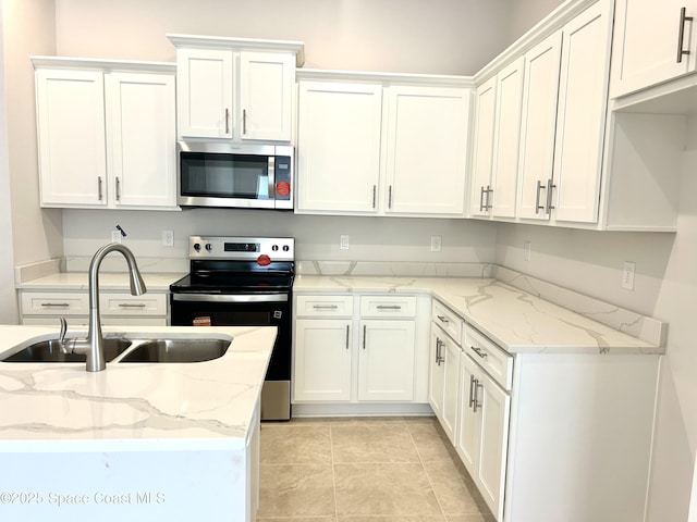 1245 Kylar Dr NW, Palm Bay, FL 32907 - kitchen featuring stainless steel appliances, white cabinets, light stone counters, and light tile patterned flooring