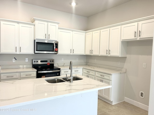 1245 Kylar Dr NW, Palm Bay, FL 32907 - kitchen with appliances with stainless steel finishes, white cabinets, light stone countertops, and light tile patterned floors