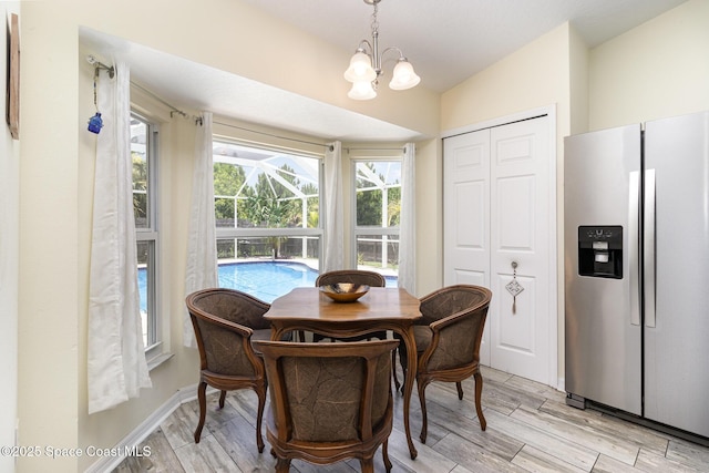 2606 Tepee Ave SE, Palm Bay, FL 32909 - dining room with a chandelier, light wood-style flooring, and vaulted ceiling