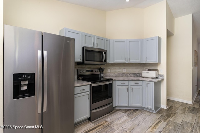 2606 Tepee Ave SE, Palm Bay, FL 32909 - kitchen featuring appliances with stainless steel finishes, backsplash, light countertops, light wood-type flooring, and high vaulted ceiling