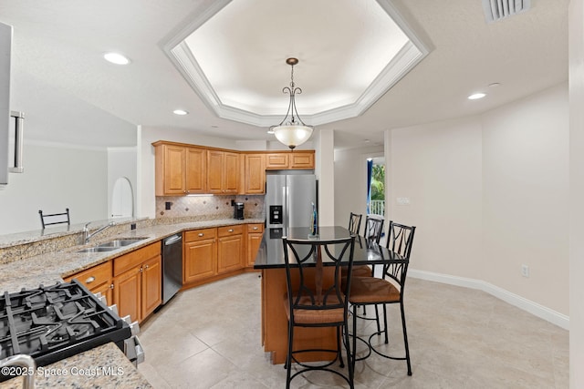 1 Eighth Ave Unit 1201, Indialantic, FL 32903 - kitchen with appliances with stainless steel finishes, light stone countertops, decorative backsplash, a breakfast bar area, and decorative light fixtures