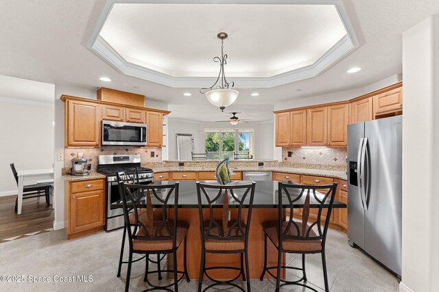 1 Eighth Ave Unit 1201, Indialantic, FL 32903 - kitchen with appliances with stainless steel finishes, recessed lighting, a tray ceiling, backsplash, and a kitchen breakfast bar