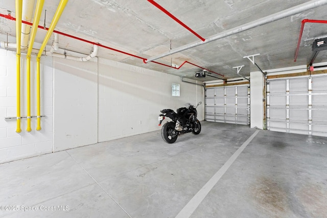 1 Eighth Ave Unit 1201, Indialantic, FL 32903 - garage featuring a garage door opener and concrete block wall