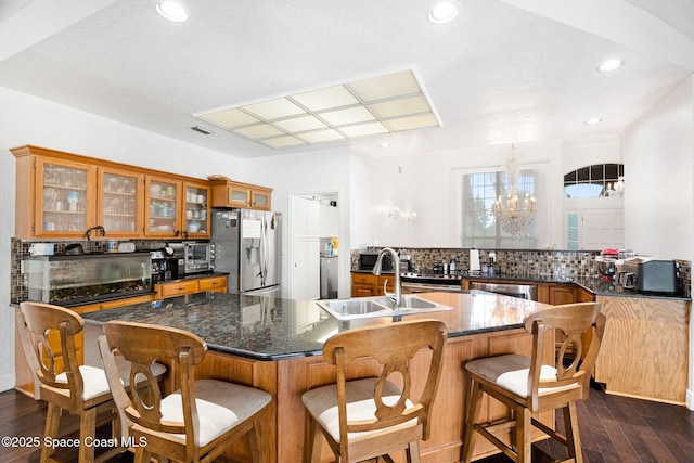 405 Lake View Ln, Grant-Valkaria, FL 32909 - kitchen with stainless steel fridge, brown cabinetry, dark wood-style floors, and recessed lighting