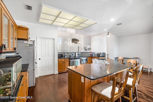 405 Lake View Ln, Grant-Valkaria, FL 32909 - kitchen featuring appliances with stainless steel finishes, dark wood finished floors, and brown cabinetry
