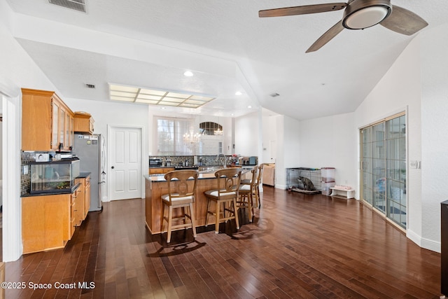 405 Lake View Ln, Grant-Valkaria, FL 32909 - kitchen with freestanding refrigerator, dark wood finished floors, ceiling fan, a kitchen breakfast bar, and recessed lighting