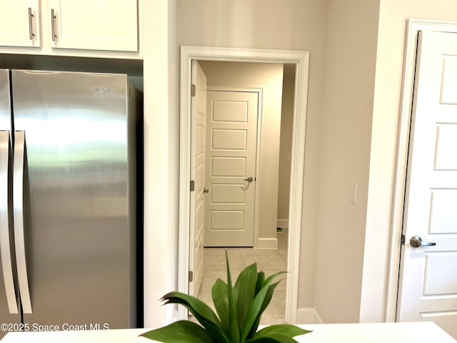 1225 Kylar Dr NE, Palm Bay, FL 32907 - kitchen with freestanding refrigerator, white cabinetry, and light tile patterned floors