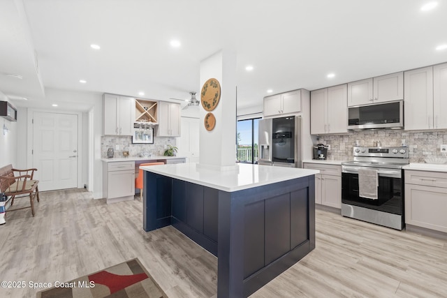 1525 S Atlantic Ave Unit 401, Cocoa Beach, FL 32931 - kitchen featuring stainless steel appliances, decorative backsplash, light countertops, light wood-style flooring, and recessed lighting