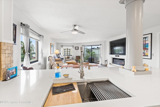 1525 S Atlantic Ave Unit 401, Cocoa Beach, FL 32931 - kitchen with open floor plan, decorative columns, a glass covered fireplace, and ceiling fan