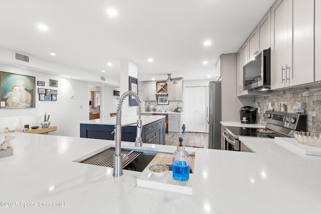 1525 S Atlantic Ave Unit 401, Cocoa Beach, FL 32931 - kitchen with appliances with stainless steel finishes, light countertops, tasteful backsplash, recessed lighting, and ceiling fan