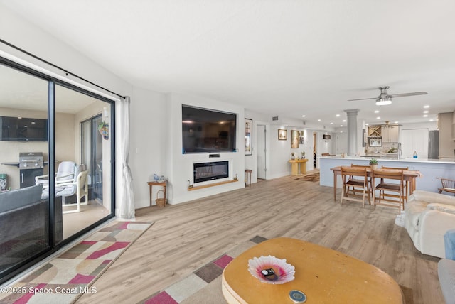 1525 S Atlantic Ave Unit 401, Cocoa Beach, FL 32931 - living room with light wood-style flooring, recessed lighting, ceiling fan, and a glass covered fireplace