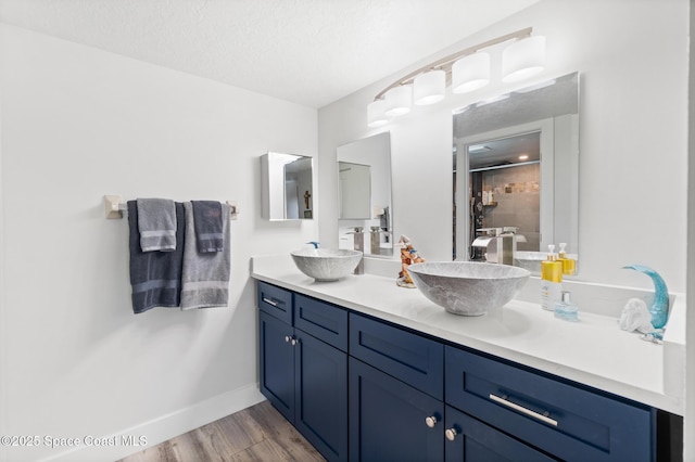 1525 S Atlantic Ave Unit 401, Cocoa Beach, FL 32931 - bathroom with double vanity, a stall shower, wood finished floors, and a textured ceiling
