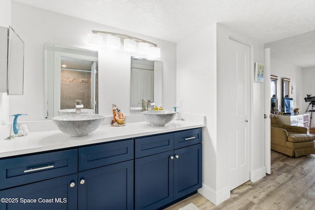 1525 S Atlantic Ave Unit 401, Cocoa Beach, FL 32931 - bathroom featuring double vanity, wood finished floors, and tiled shower
