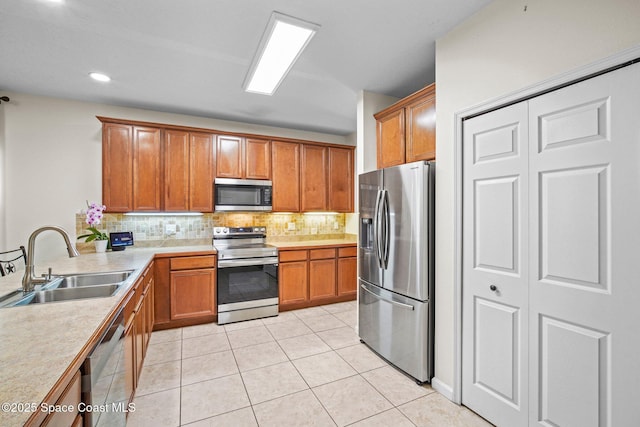 500 Loxley Ct, Titusville, FL 32780 - kitchen with appliances with stainless steel finishes, brown cabinetry, decorative backsplash, light countertops, and light tile patterned floors