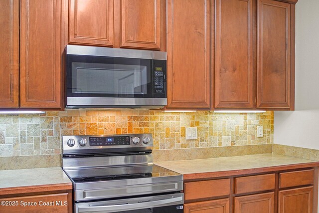500 Loxley Ct, Titusville, FL 32780 - kitchen with appliances with stainless steel finishes, light countertops, backsplash, and brown cabinets